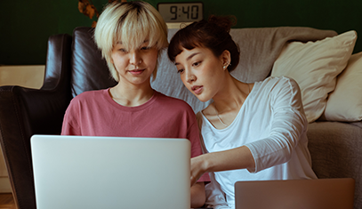 two people sitting on floor with laptops