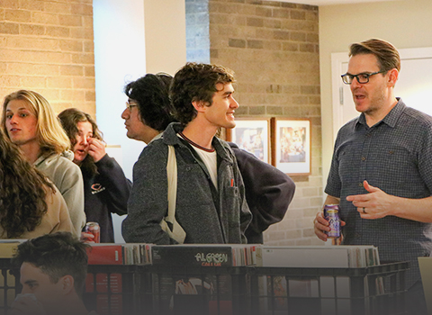 student talking to faculty at a dinner