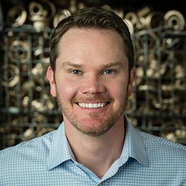 man with dark blonde hair and beard smiling