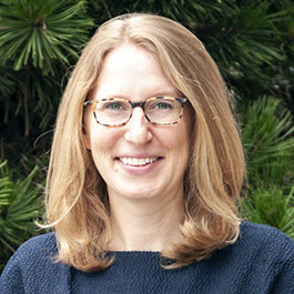 woman with blonde hair and glasses smiling