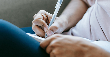 Person writing in notepad