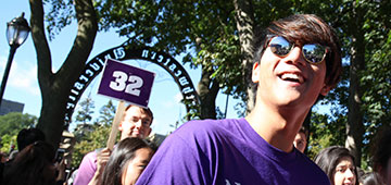 students marching through the arch