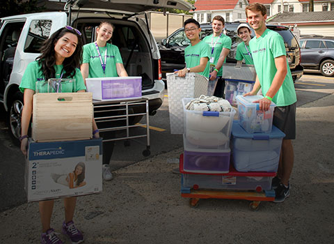 purple posse helping a new student move in