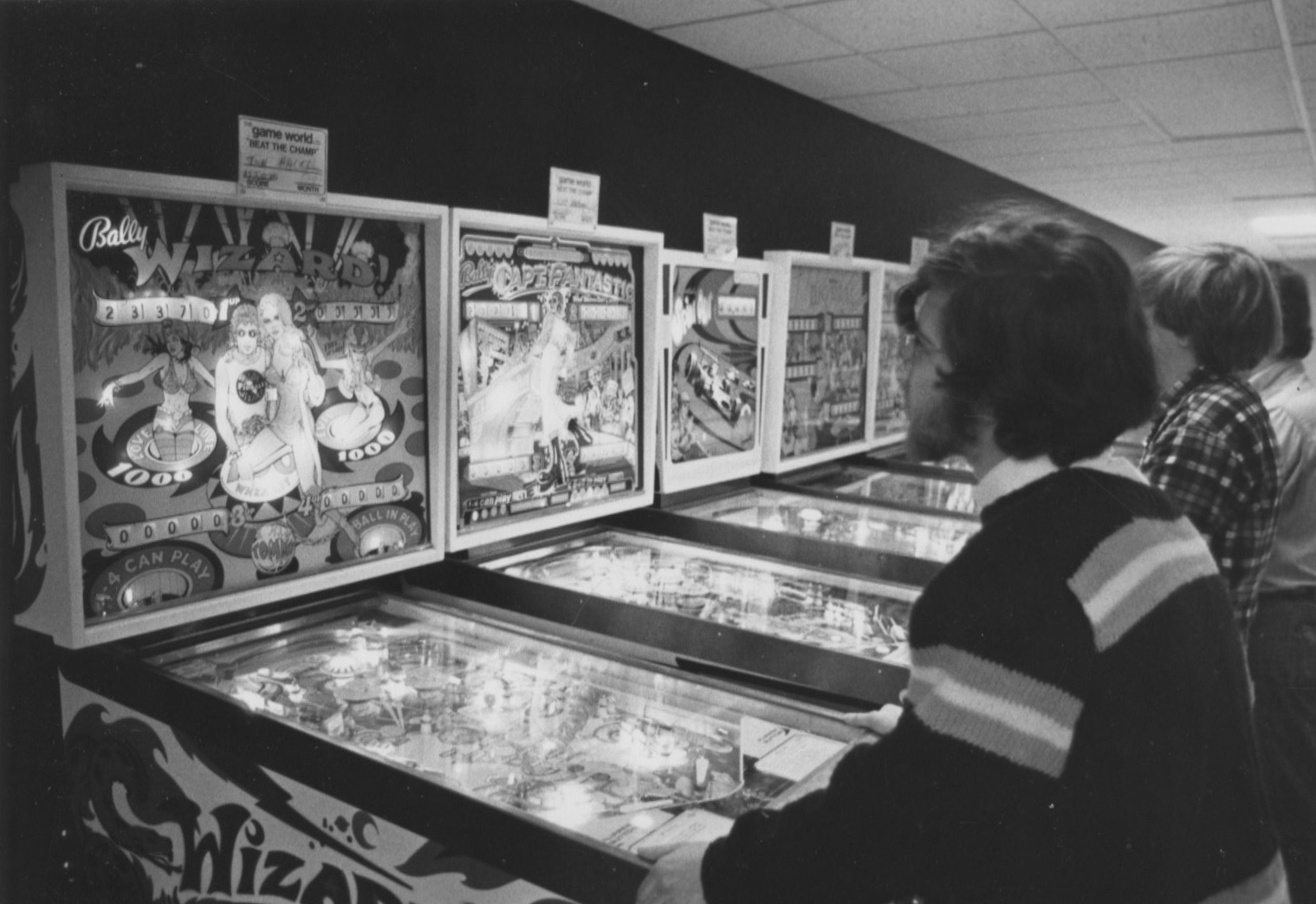Black and white photo of. students playing arcade games