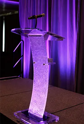 lectern with microphone on a purple-lit event stage