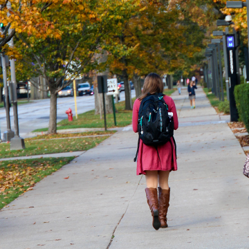 student walking blue emergency light on path