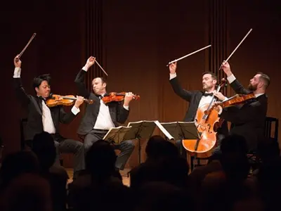 people playing string instruments on stage