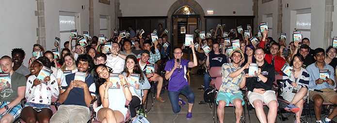 Students in a classroom all holding the new One Book selection