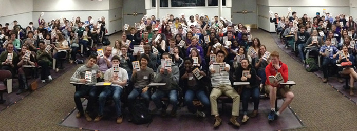 Students in a classroom all holding the new One Book selection