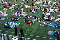 At Northwestern Medicine Field at Martin Stadium, President Chiang takes a photo of the Evanston community at Community Movie Night.