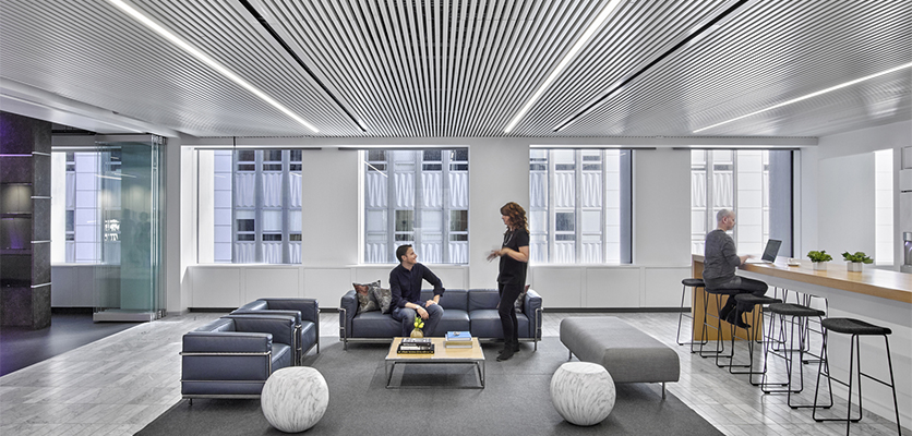Three people interact in a work space