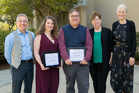 Group of five, smiling, two award winners holding awards