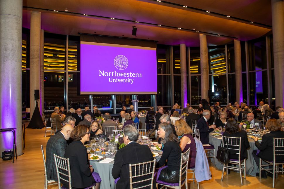 People sit at tables during a formal event.