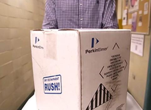 Man pushing a box with a package of radioactive materials on it