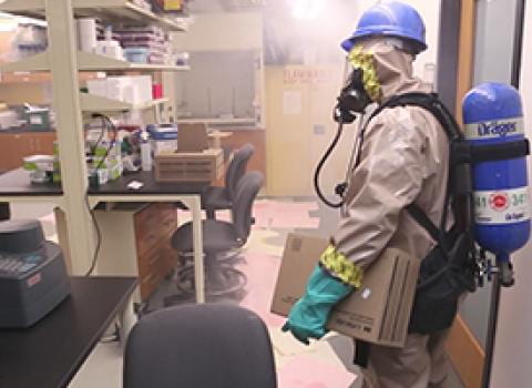 Firefighter in protective suit and respirator in a lab with smoke in the air