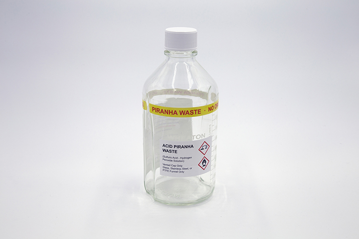Glass bottle with piranha waste label
