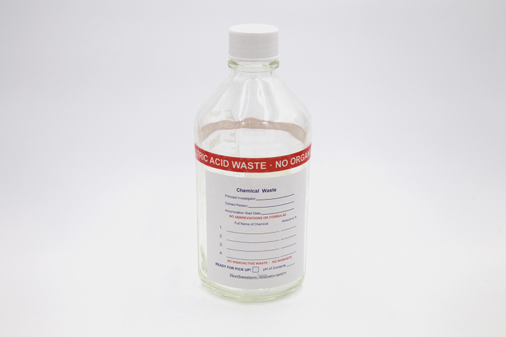 Glass bottle with nitric acid waste label