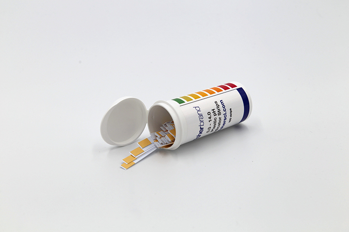 White opened canister with ph strips sticking out