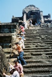 Visitors to Angkor Wat in Cambodia carefully descend from the Khmer temple tower.