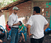 Peace Corps administrator Bryan Dwyer talks with a doctor, who is part of a medical brigade, in a small Salvadoran village with no medical services of its own.