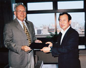 John Kares Smith accepts bound copies of peace declarations from Tadatoshi Akiba, mayor of Hiroshima.