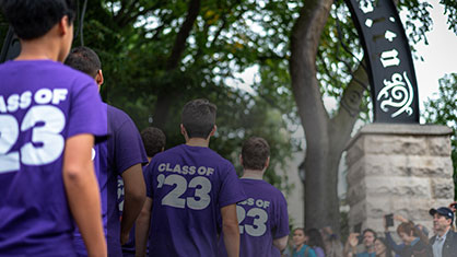 students walking to the arch with class of 2023 T-shirts on