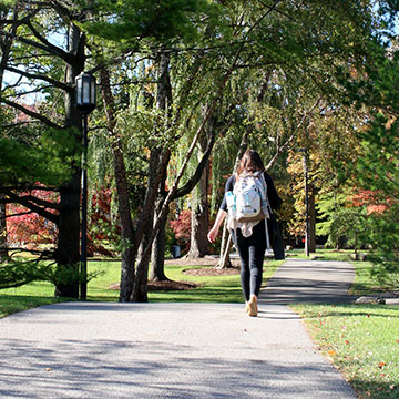 student walking on campus with backpack