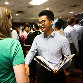 student greeting a company representative