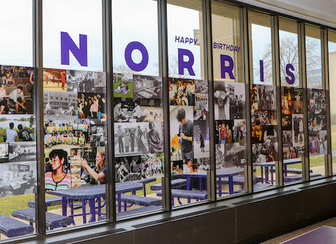 A large photo collage is shown on a set of windows. Above it reads "Happy Birthday Norris" in purple.