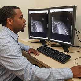 man examining xray scans