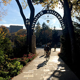student biking through the arch