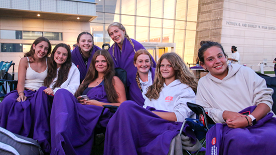 students waiting for movie to start on lawn