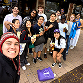 A group of students post outdoors for a selfie
