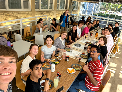A group of students post for a selfie at a lunch table