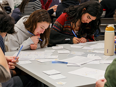 Students play Point Taken, the collaborative writing-based game designed to increase openness and decrease animosity for discussing contentious issues.
