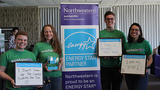 Group at campus fair with signs that talk about how they help the environment