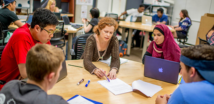 Students around a table with an instructor.