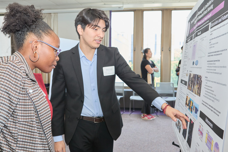 two people looking at a poster