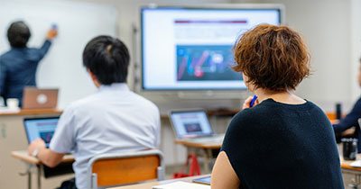 Man and woman sitting in the classroom listening to a professor