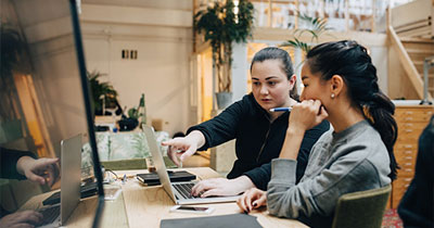 Two women working together and talking