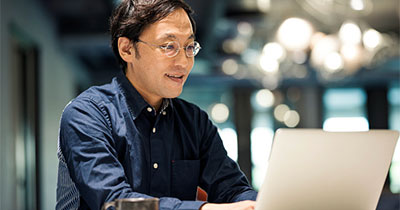 A man working on a laptop and smiling