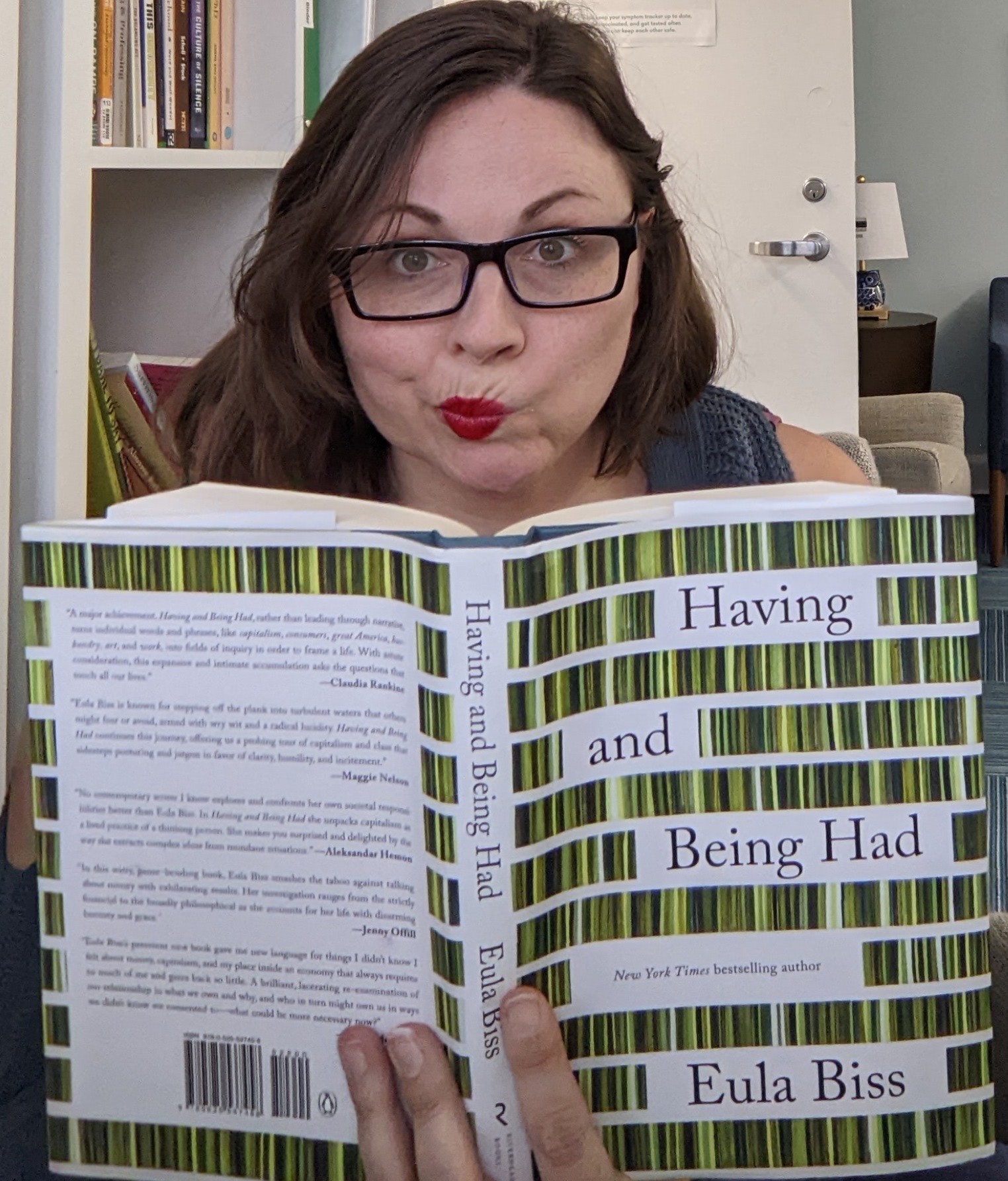 photo of Sarah Brown holding Having and Being Had by Eula Biss